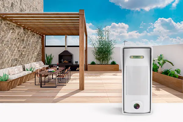 Detector exterior con cámara Sensor de movimiento con cámara con el perímetro de una terraza de grandes dimensiones de una casa baja o un ático detrás.